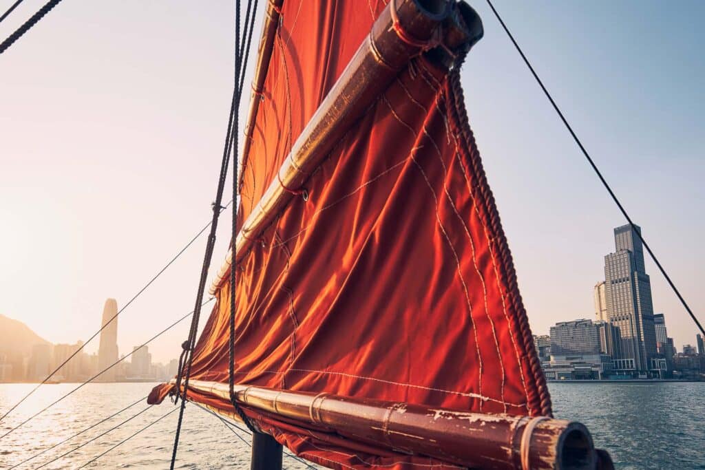 Traditional Junk boat against Hong Kong cityscape