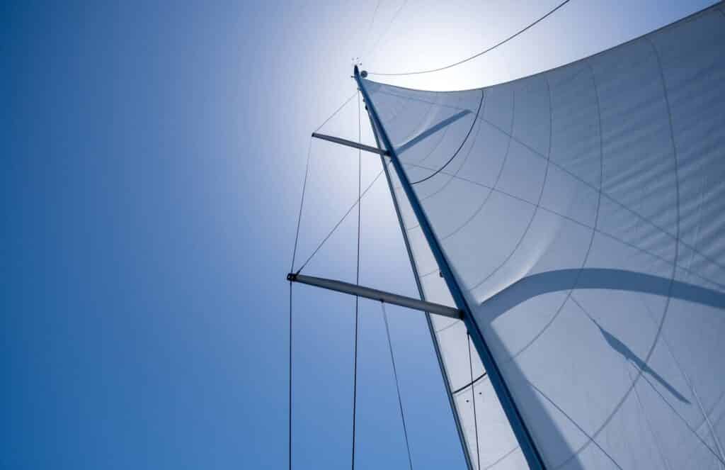 Yacht sails on clear blue sky background